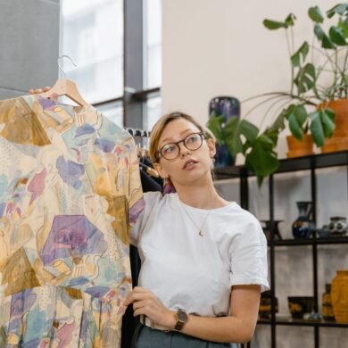 woman in white shirt holding multi colored dress