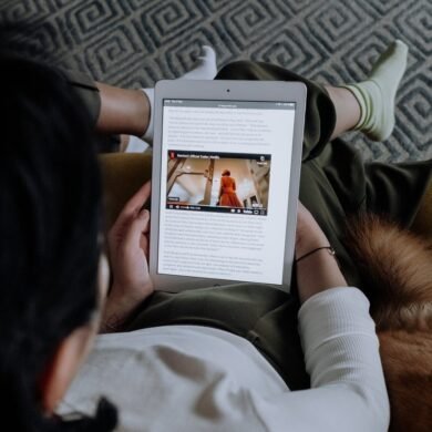 woman in white long sleeve shirt holding a tablet