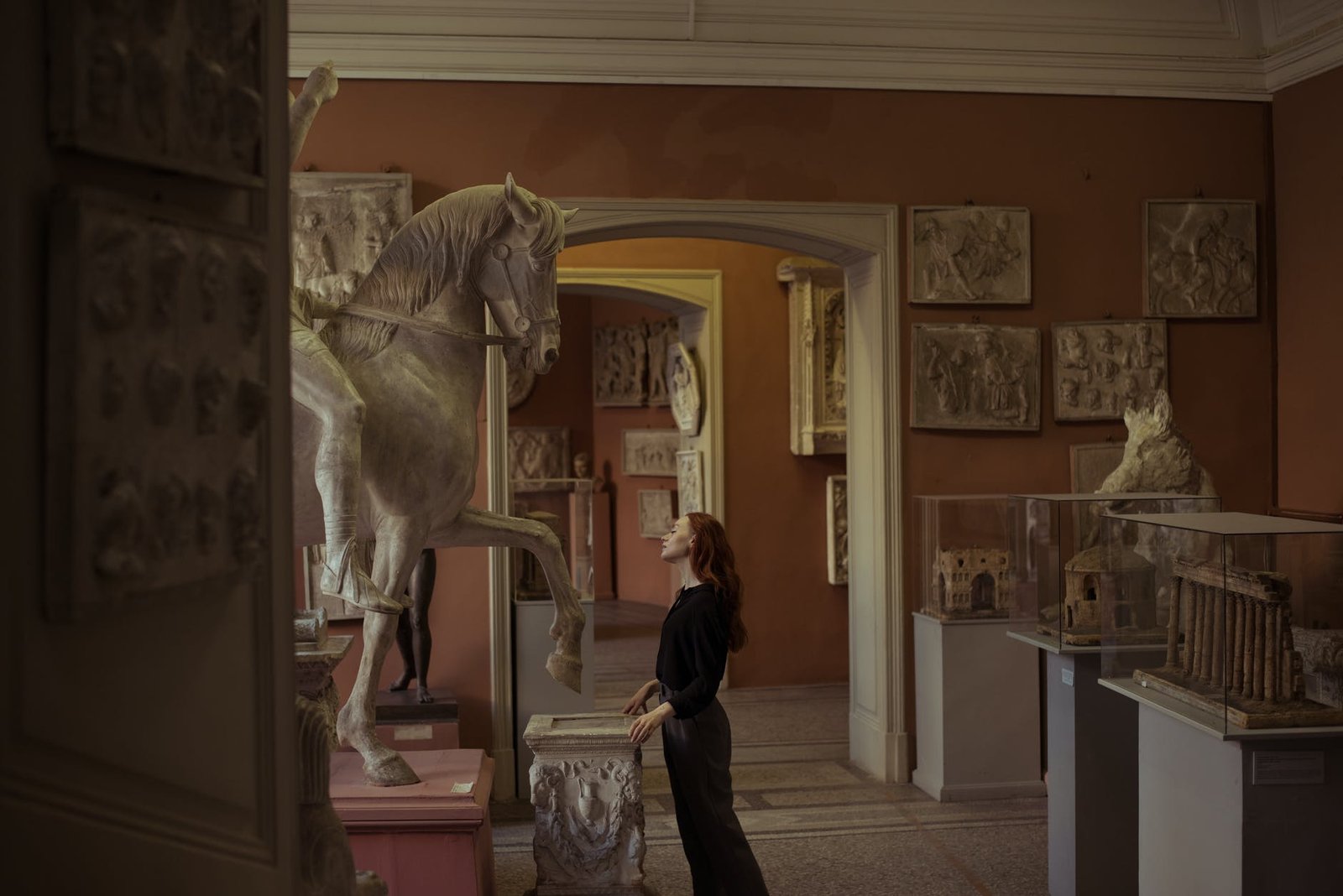 woman looking at a horse sculpture in a museum