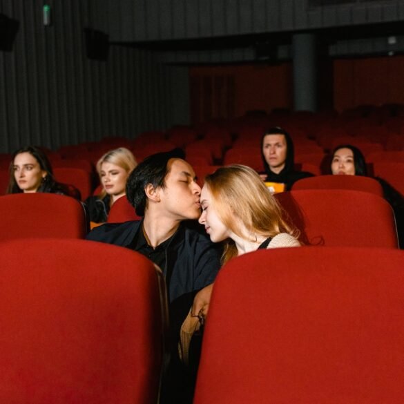 a man kissing a woman s forehead in a movie theater