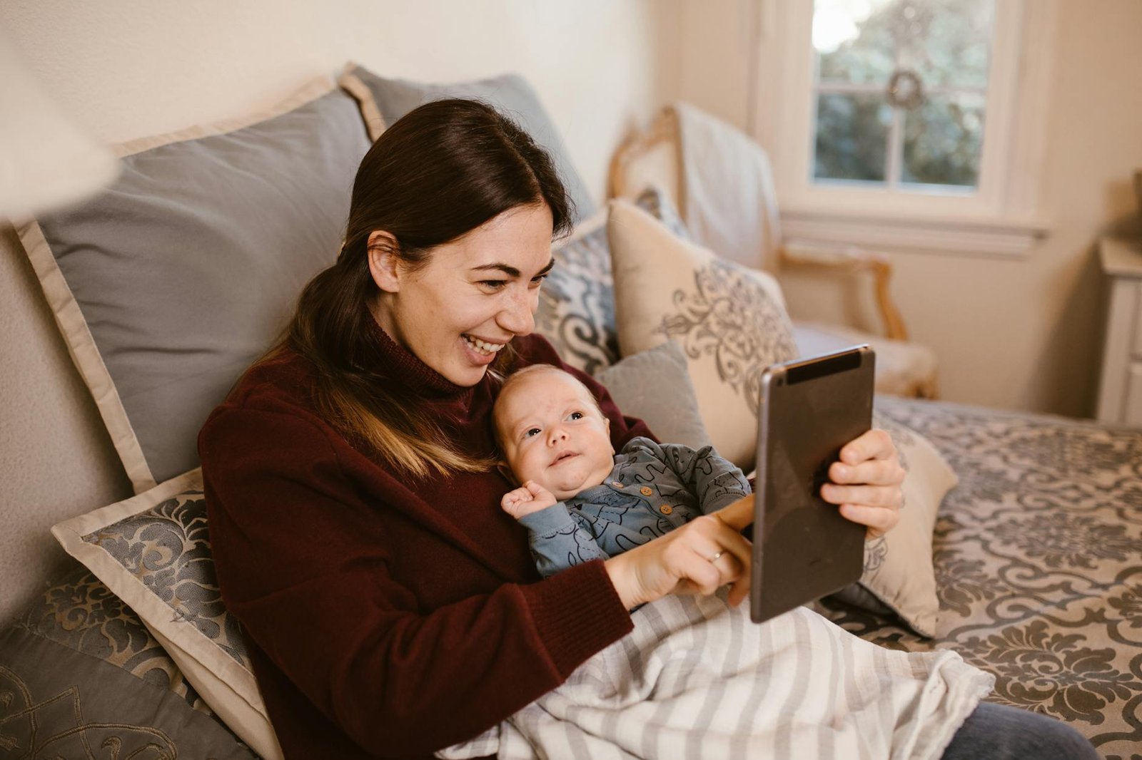 mother holding her baby while having a video call using a tablet